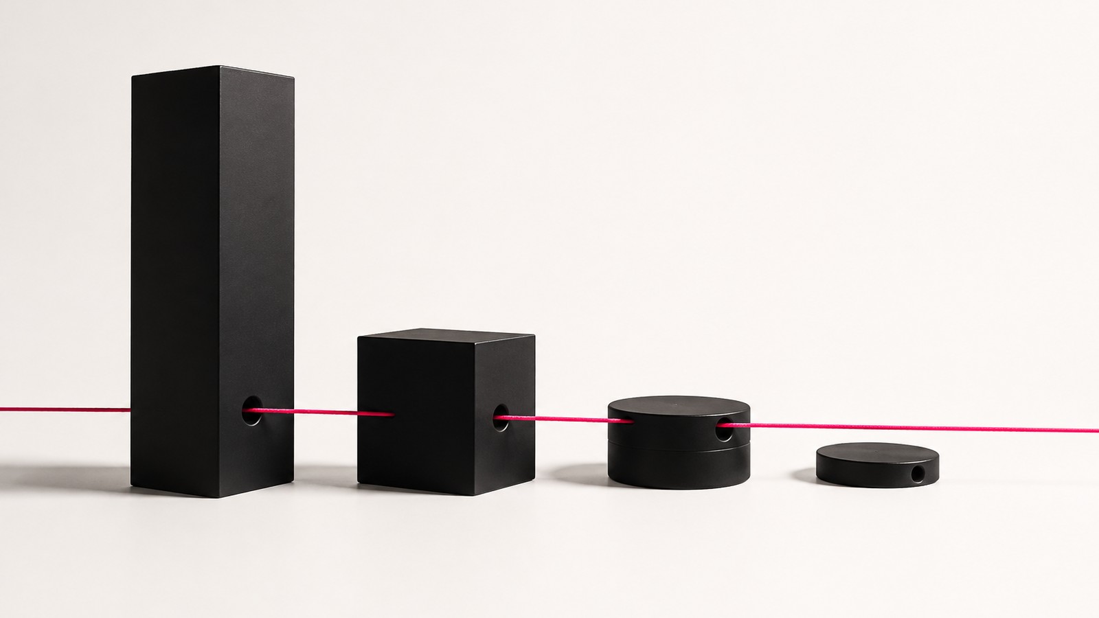 Four matte-black forms of descending size connected by a single continuous thread, representing one consistent training standard running through every level of a company
