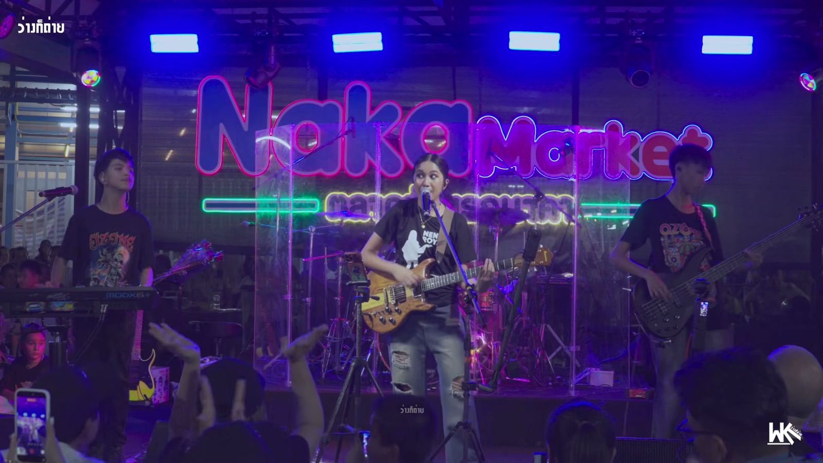 Nene Royal performing with OZONE Band under the lit Naka Market sign in Phuket, Thailand, on August 16, 2026, nine days before her AGT Golden Buzzer